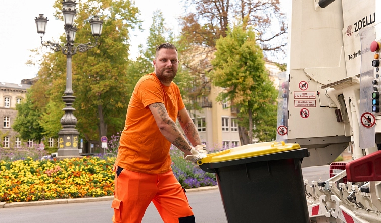Müllwerker zieht die gelbe Wertstofftonne